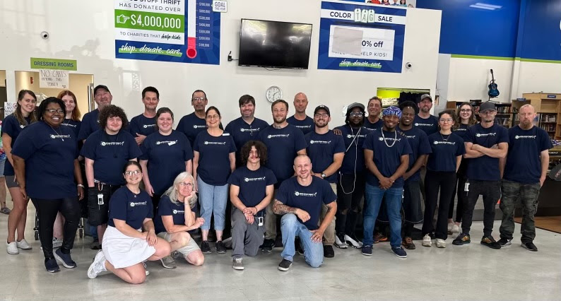 A group of people wearing blue shirts and posing for the camera.