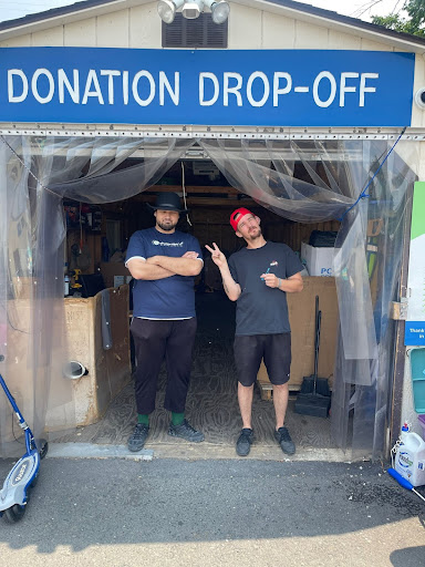 Two men standing in front of a donation drop off.