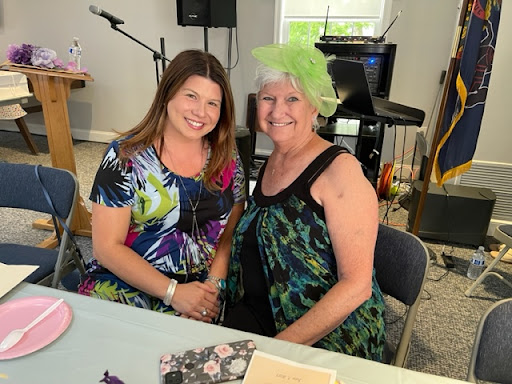 Two women posing for a picture at an event.