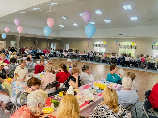 A group of people sitting at tables eating food.