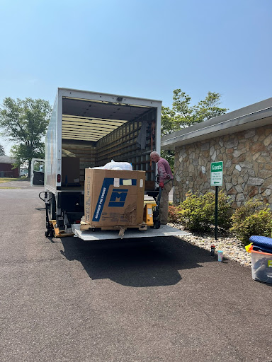 A man unloading boxes from the back of a truck.