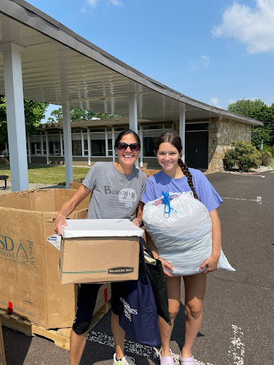 Two women standing next to a box of boxes.