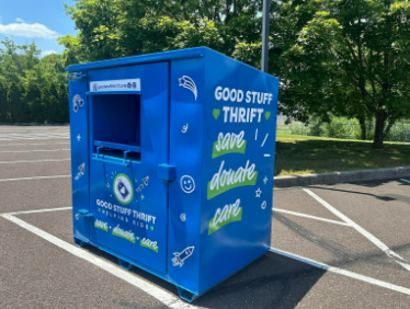 A blue box sitting in the middle of a parking lot.