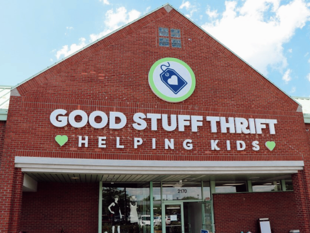 Thrift store front with "Helping Kids" sign.